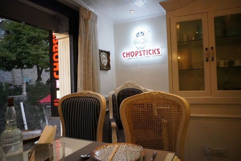 Stylish chopsticks with fresh Asian food on the table